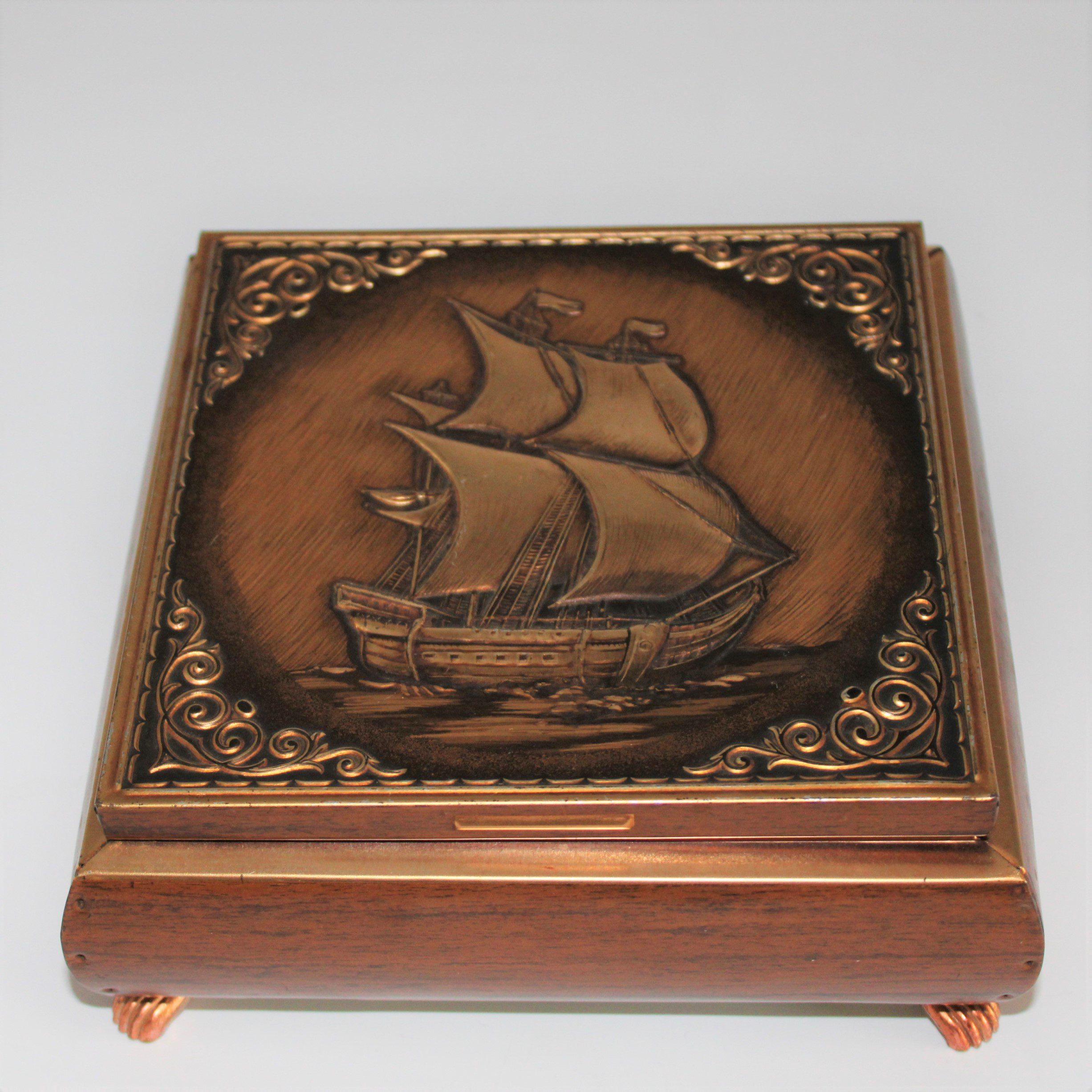 Vintage blik op pootjes met houtnerf decoratie en afbeelding schip